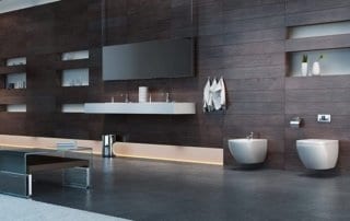 Modern bathroom with dark wood wall panels, two bidets, and a wall-mounted sink.