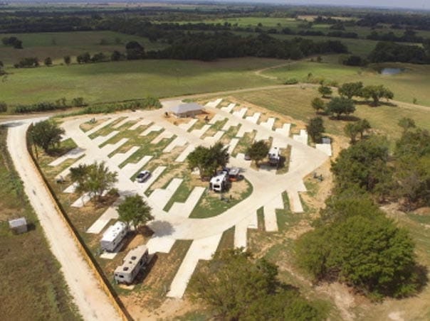 Aerial view of a RV park with organized parking spots and surrounding greenery in Copper Ridge, Texas.